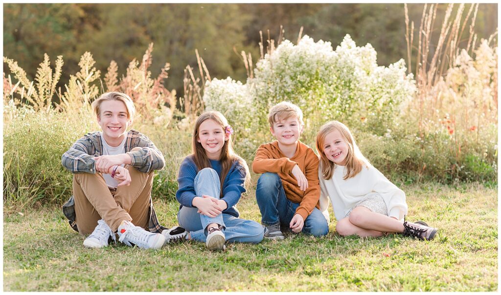 Fall pictures of 4 siblings sitting down taken at the Raleigh NC art Museum. 