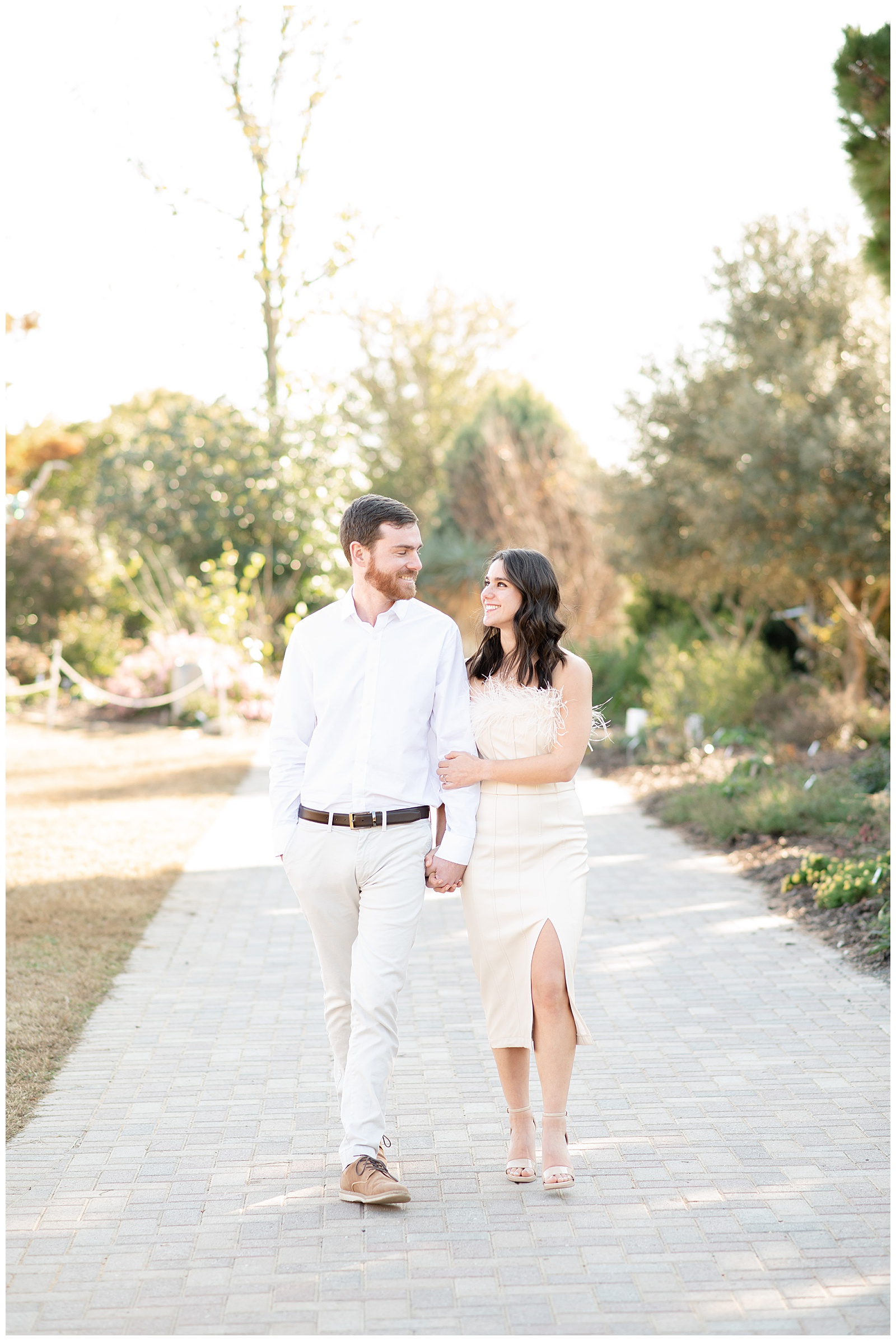 A couple walking together during their engagement session at the JC Raulston Arboretum in Raleigh, NC
